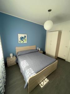 1 dormitorio con 1 cama con pared azul en Villetta Azzurra, en Alcamo Marina