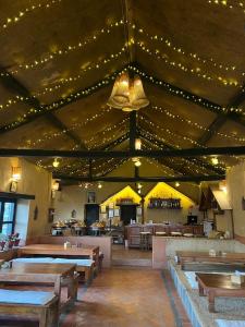 un restaurante con mesas de madera y luces en el techo en Prakriti Resort and Organic Farm Pvt. Ltd. en Burhānilkantha