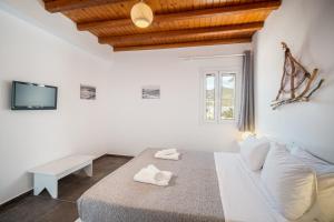 um quarto branco com uma cama e um sofá em Ta Kabia Studios em Rámos