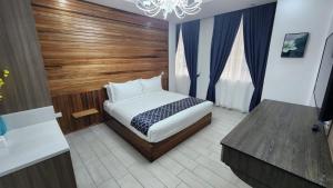 1 dormitorio con 1 cama con pared de madera en Comfort Inn, 