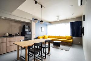 a kitchen and dining room with a table and yellow couch at Section L Tsukiji in Tokyo