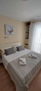 a bedroom with a large bed with two towels on it at Pahljina Apartments in Rab