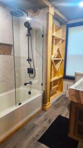 a bathroom with a shower and a bath tub at Rustica Retreats Cottage in Middle Grove +19 photos