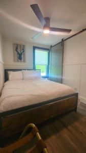 una camera con letto e ventilatore a soffitto di Rustica Retreats Cottage a Middle Grove