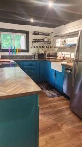 una cucina con armadi blu e piano di lavoro di Rustica Retreats Cottage a Middle Grove
