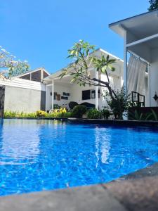 una piscina azul frente a una casa en Danima Resort & Restaurant, en Gili Trawangan