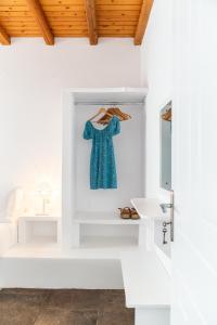 Ta Kabia Studios في Rámos: حمام أبيض مع ثوب أزرق معلق على الحائط
