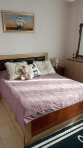 a bed with a teddy bear sitting on top of it at A&K Sea View Apartament 6 in Durrës