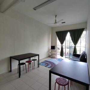 uma sala de estar com uma mesa e bancos em Homestay Nilai (Anggerik Court) em Nilai