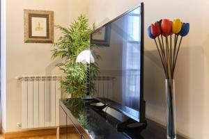 TV de pantalla plana sobre una mesa de cristal en El pixin - Apartamento de gran categoría en GIJON, en Gijón