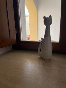 a white vase sitting on the floor next to a window at La Pulchella in LʼAquila