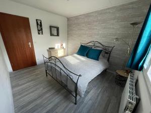 1 dormitorio con cama de metal y almohadas azules en Gîte Le Pti Chouta en Anhée