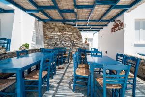 una fila de mesas y sillas azules en un restaurante en Ta Kabia Studios, en Rámos