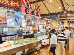 um grupo de pessoas em pé em um mercado de frutos do mar em Whole house rental 一棟貸切宿 "Your Home Tottori" 市内中心地近くの素敵な一軒家 em Tottori