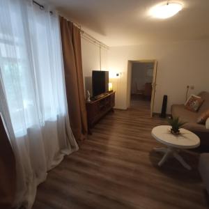 ein Wohnzimmer mit einem Sofa, einem Tisch und einem TV in der Unterkunft The Golden Well in Rovinj