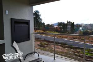 a balcony with a flat screen tv and a chair at Uitzicht in Dullstroom +8 photos