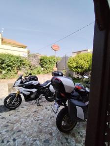two motorcycles parked next to each other on a driveway at B&B Villa Liliya in Fiumefreddo di Sicilia