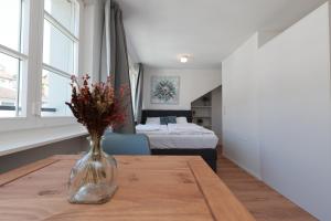 a vase with flowers on a table in a room at KoBi Apartments Falkenplatz in Luzern