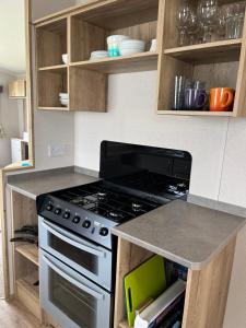 a kitchen with a stove and a counter top at Arizona - Pura Vida Holidays Caravan in Clacton-on-Sea