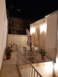 a balcony with tables and chairs on a house at night at San Domenico Casa Vacanze in Modica
