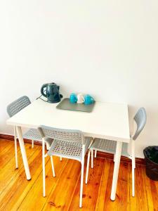 a white table and chairs with a tea pot on it at Atlas' House in Poznań