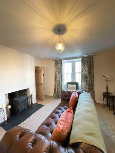 a living room with a couch and a fireplace at Watherston Farm Cottage in Stow
