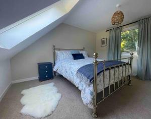 a bedroom with a bed with a blue comforter and a window at Watherston Farm Cottage in Stow