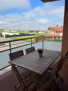 - Balcón con mesa de madera y 2 sillas en Apartamento Turistico Tempranillo, en Cirueña