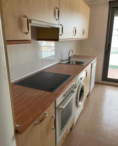 a kitchen with a sink and a stove top oven at Apartamento Turistico Tempranillo in Cirueña