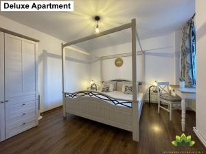 a bedroom with a canopy bed and a desk at Sibiu Lotus Apartments in Sibiu