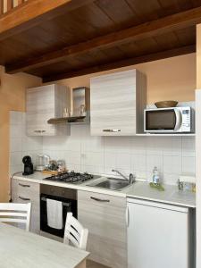 eine Küche mit einer Spüle und einer Mikrowelle in der Unterkunft CASA VACANZA TINDARA in Civitavecchia