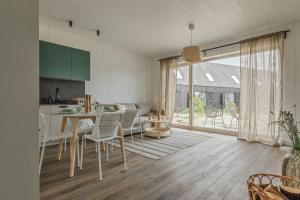 Una cocina y un comedor con mesa y sillas. en Svencelės burė 2, en Svencelė