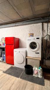 a laundry room with a washing machine and a red refrigerator at GITE LE COQ ROUGE in Eguisheim