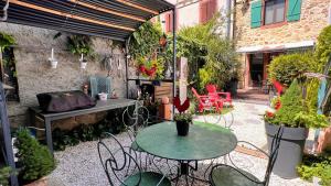 a patio with two tables and chairs and plants at GITE LE COQ ROUGE in Eguisheim