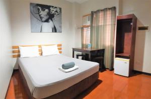 una camera da letto con un letto grande e un tavolo di Hotel California Suite a Sudtungan