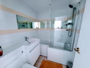 a white bathroom with a shower and a sink at Tackleway privileged Sea Views Hastings old town whole house 3 beds in Hastings