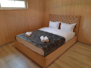a bedroom with a bed with two slippers on it at Elegia in Arsha