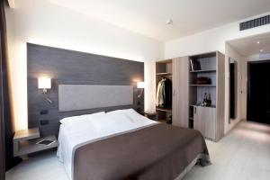 a bedroom with a large bed and a wall at Hotel Giardino in Arona