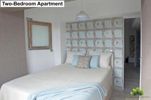 シビウにあるSibiu Lotus Apartmentsのベッドルーム(白いベッド、青い枕付)