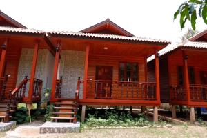 a wooden house with a porch and a staircase at Konglor Cave Resort in Ban O