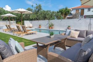 un patio con tavolo e sedie e una piscina di Villa Estia ad Alikanás