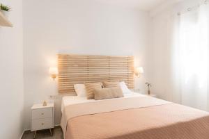 una camera bianca con un grande letto con testiera in legno di Villa Estia ad Alikanás Altre 51 foto
