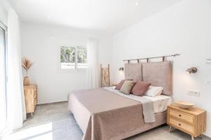 una camera da letto bianca con un letto grande e un tavolo di Villa Estia ad Alikanás