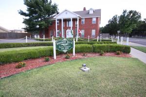 un cartel en un patio frente a una casa en Woodrow House Bed & Breakfast en Lubbock