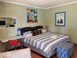 1 dormitorio con cama, escritorio y silla en 3 Brothers B&B, en Edenvale