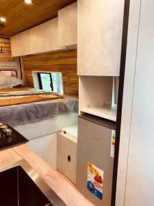 a kitchen with two beds and a refrigerator in a room at best camper van in tbilisi in Tbilisi City