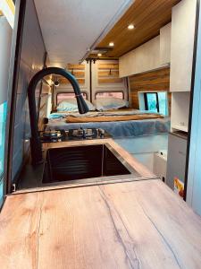 a kitchen in an rv with a sink and a bed at best camper van in tbilisi in Tbilisi City