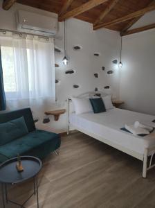 a bedroom with a white bed and a green couch at Orange Garden Double Rooms in Kala Nera