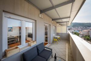 een balkon met een bank en een groot raam bij Apartment Lapad in Dubrovnik