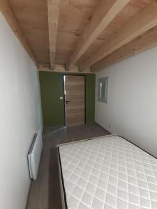 um quarto com uma cama num quarto com uma porta em Gîte le Nid du Colibri - 12 pers em Brenoux